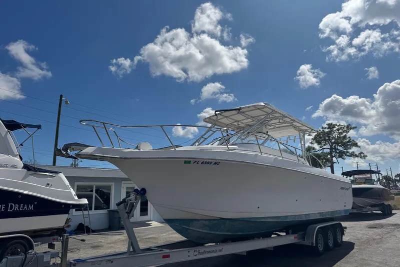 The Image of 2001 Pro-Line 30 Express boat on trailer under blue sky with clouds. - 1