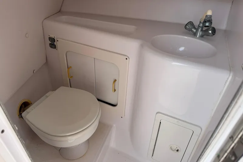 Slide: The Image of 2001 Pro-Line 30 Express boat bathroom with toilet, sink, and storage cabinets. - 32