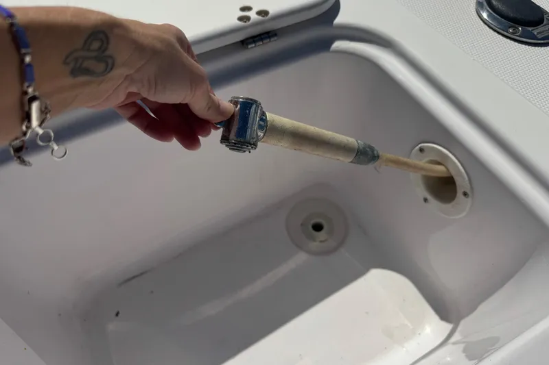 Slide: The Image of Hand holding a hose inside a Pro-Line 30 Express boat compartment, 2001 model. - 39