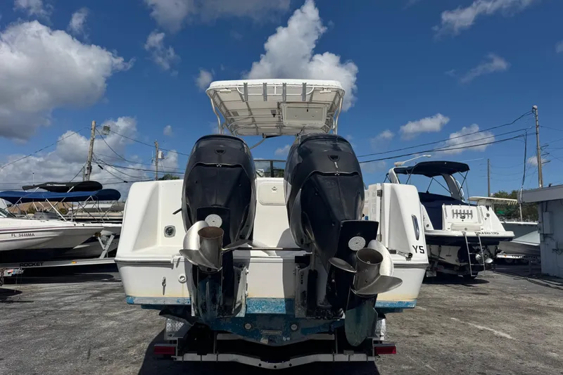 Slide: The Image of 2001 Pro-Line 30 Express boat with dual outboard motors, docked under a clear blue sky. - 4