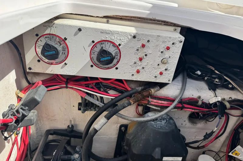 Slide: The Image of Electrical panel of a 2001 Pro-Line 30 Express boat with wiring and battery switches. - 52