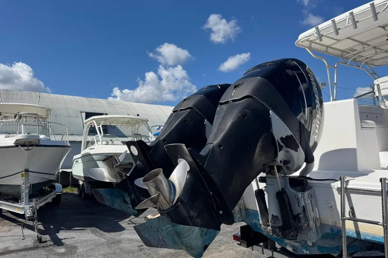 Slide: The Image of 2001 Pro-Line 30 Express boat with dual outboard motors, parked under a clear blue sky. - 57