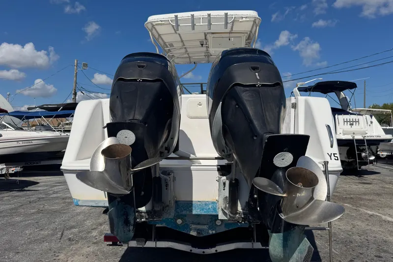 Slide: The Image of 2001 Pro-Line 30 Express boat with dual outboard motors, docked under a clear blue sky. - 58