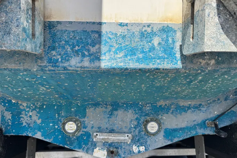 Slide: The Image of Weathered hull of a 2001 Pro-Line 30 Express boat with peeling blue paint. - 60