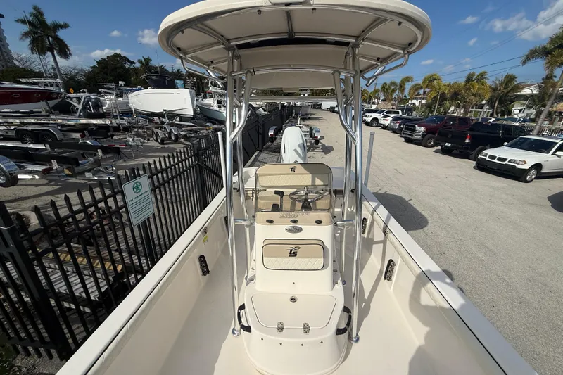 Slide: The Image of 2023 Carolina Skiff 21 LS boat with T-top, parked in a marina under a clear sky. - 10