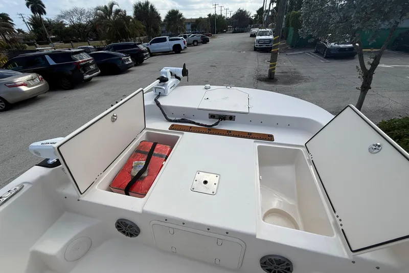 Slide: The Image of 2023 Carolina Skiff 21 LS boat with open storage compartments in a parking lot. - 11