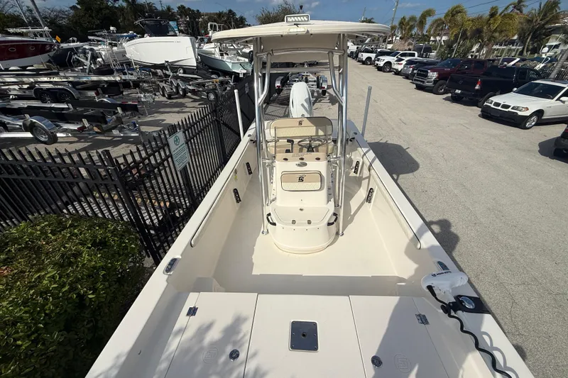 Slide: The Image of 2023 Carolina Skiff 21 LS boat in a marina, surrounded by trailers and vehicles. - 12