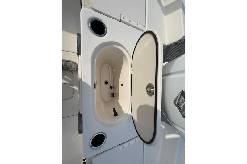 Slide: The Image of 2023 Carolina Skiff 21 LS boat storage compartment with open lid and cup holders. - 13
