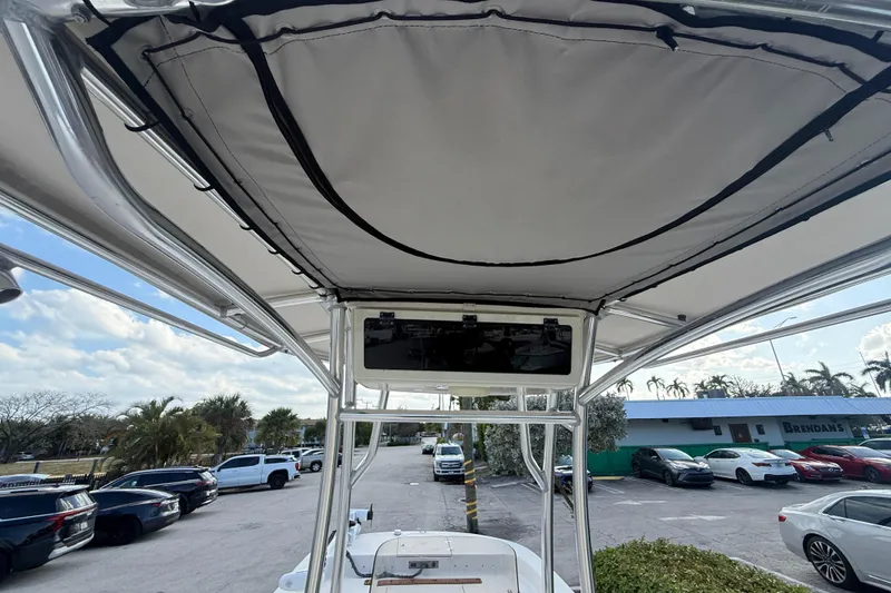 Slide: The Image of 2023 Carolina Skiff 21 LS boat with T-top, parked in a lot under a cloudy sky. - 17