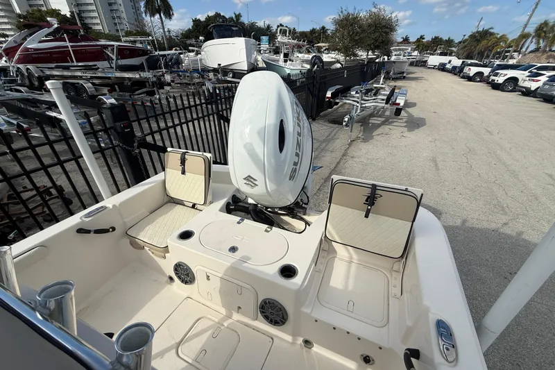 Slide: The Image of 2023 Carolina Skiff 21 LS boat with Suzuki outboard motor, docked in a marina. - 6