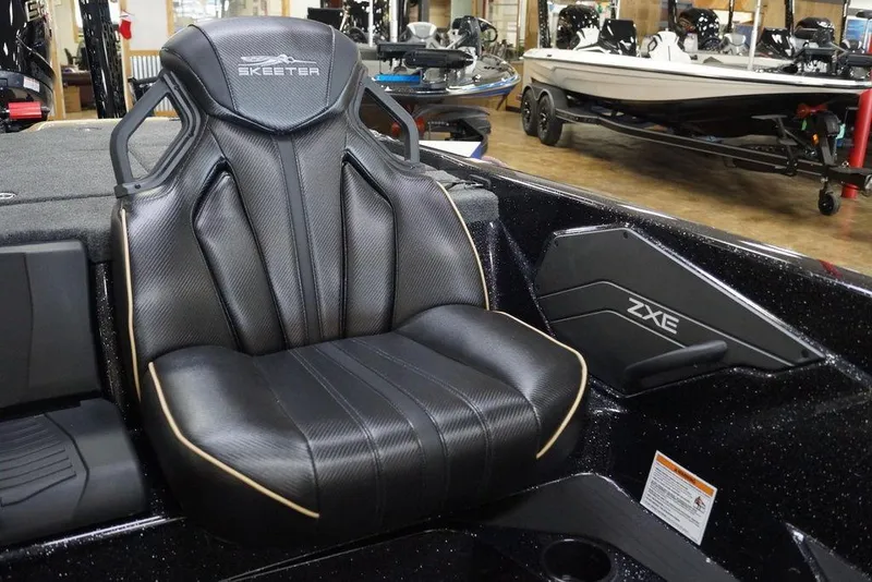 Slide: The Image of 2026 Skeeter ZXE21 boat seat in showroom, featuring sleek black design and branding. - 4