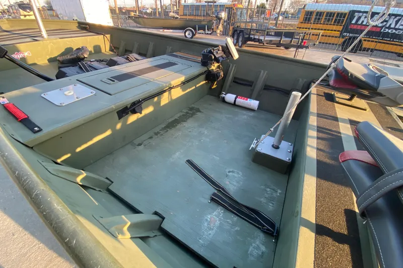 Slide: The Image of 2012 Alumacraft 1448 Jon boat interior with seating and equipment, parked outdoors. - 13