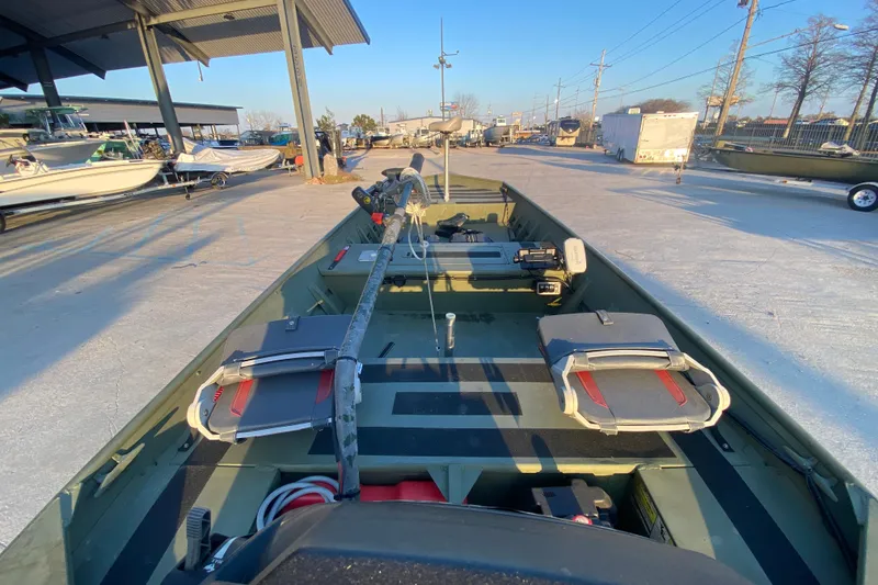Slide: The Image of 2012 Alumacraft 1448 Jon boat with seating, parked outdoors under a canopy. - 15