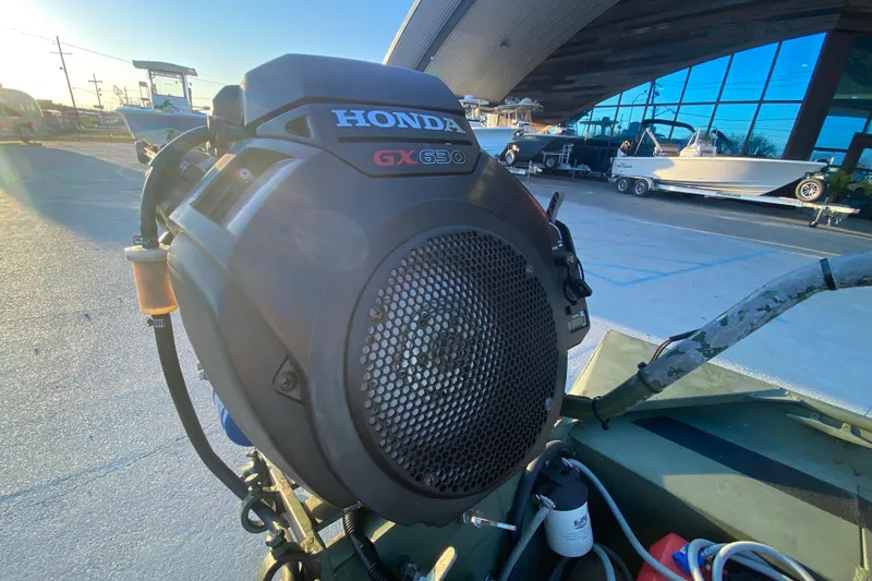 Slide: The Image of 2012 Alumacraft 1448 Jon boat with Honda GX630 engine in a marina setting. - 16