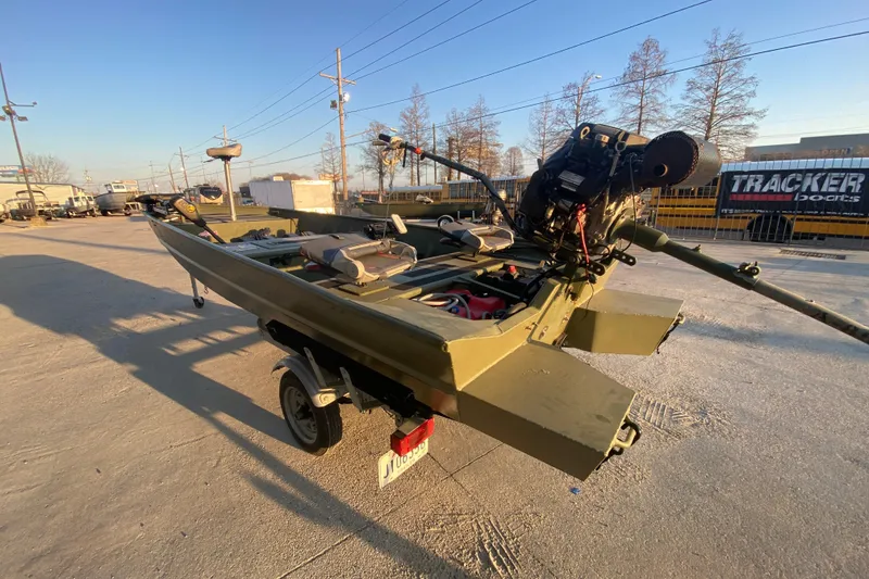 Slide: The Image of 2012 Alumacraft 1448 Jon boat on trailer, equipped with motor, parked outdoors. - 5