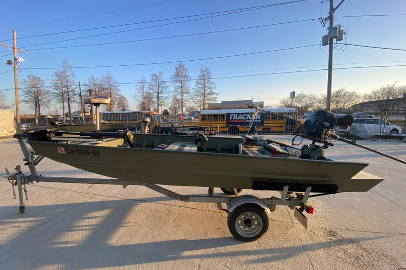 Slide: The Image of 2012 Alumacraft 1448 Jon boat on trailer, parked outdoors under clear sky. - 6