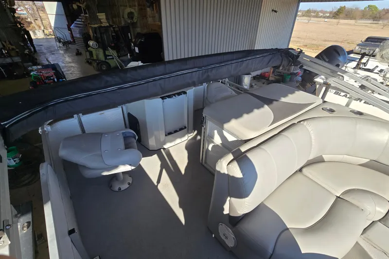 Slide: The Image of 2017 SilverWave 230 Island boat interior with gray seating and helm chair. - 12