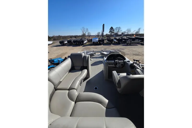 Slide: The Image of 2017 SilverWave 230 Island pontoon boat with spacious seating and steering console, parked outdoors. - 9