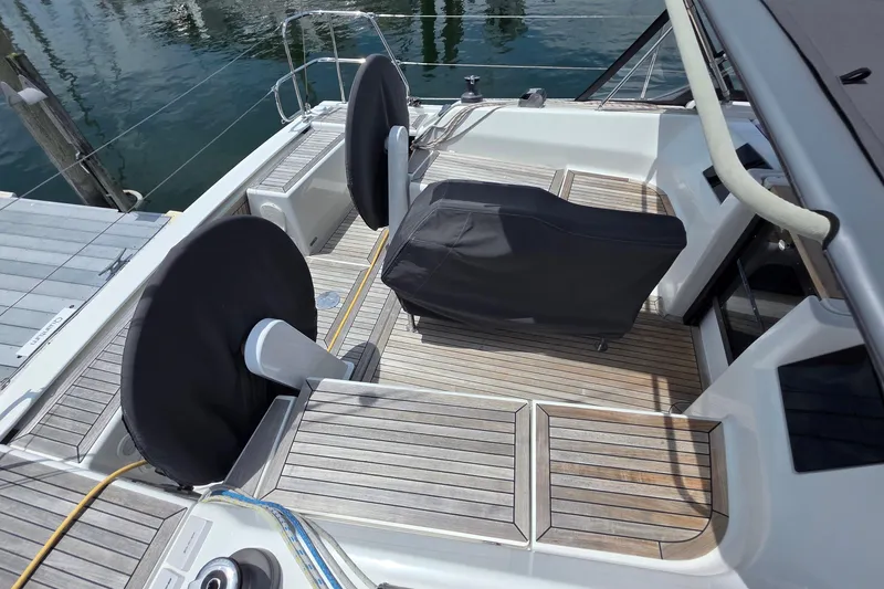 Slide: The Image of 2014 Hanse 385 yacht cockpit with covered steering wheels and wooden deck. - 13