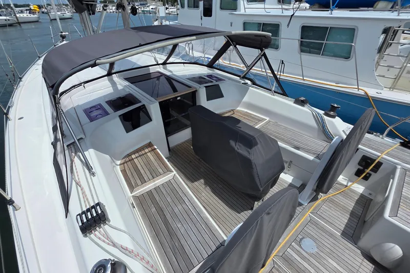 Slide: The Image of 2014 Hanse 385 sailboat cockpit with covered seating and wooden deck, docked at marina. - 15