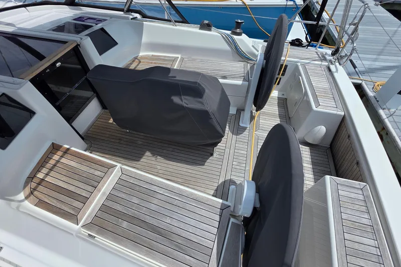 Slide: The Image of 2014 Hanse 385 yacht cockpit with covered steering wheels and wooden deck. - 16