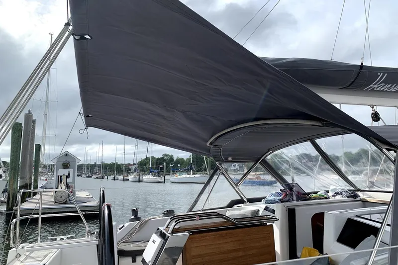 Slide: The Image of 2014 Hanse 385 sailboat docked with canopy, showcasing marina background. - 17