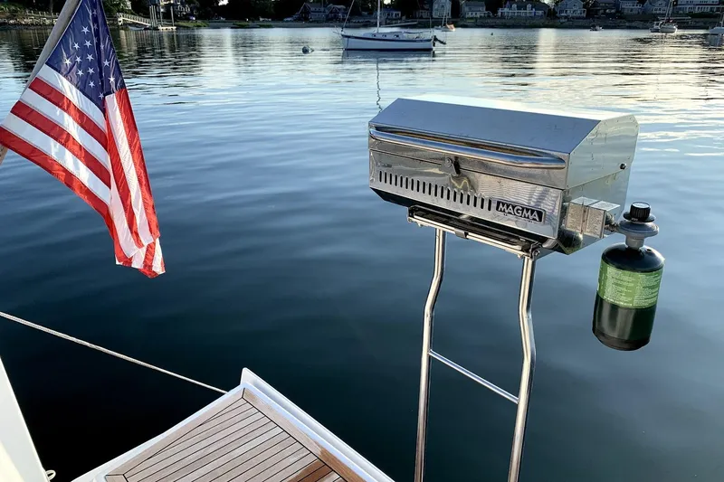 Slide: The Image of Hanse 385 sailboat with American flag and Magma grill on calm water, 2014 model. - 18