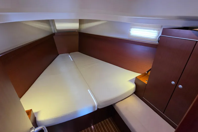 Slide: The Image of 2014 Hanse 385 yacht cabin with cozy bed and wooden cabinetry. - 19