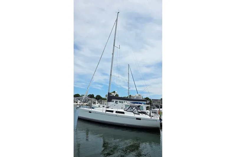 Slide: The Image of 2014 Hanse 385 sailboat docked in a marina under a cloudy sky. - 3