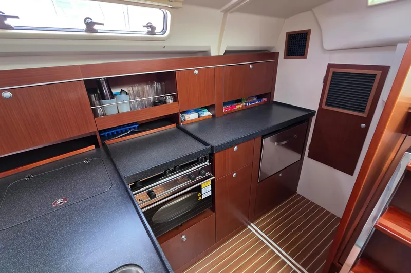 Slide: The Image of Modern galley kitchen in 2014 Hanse 385 yacht with wood cabinetry and sleek countertops. - 33