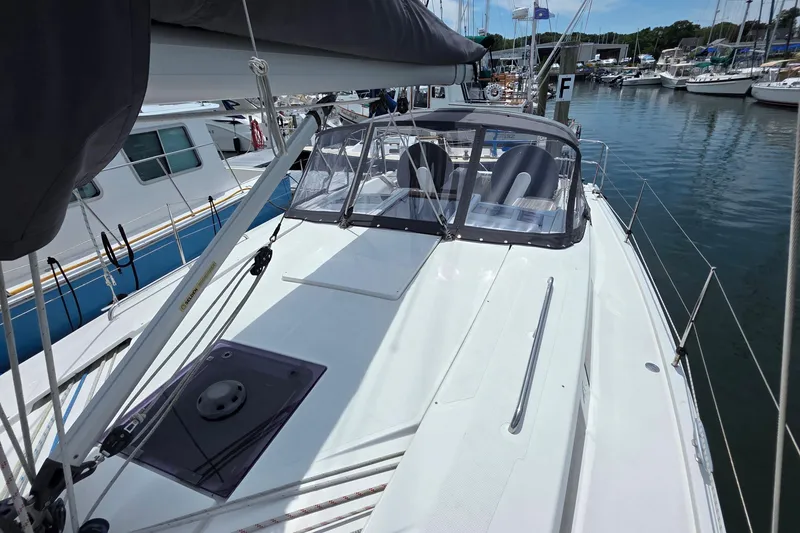 Slide: The Image of 2014 Hanse 385 sailboat docked at marina, featuring sleek deck and cockpit enclosure. - 9