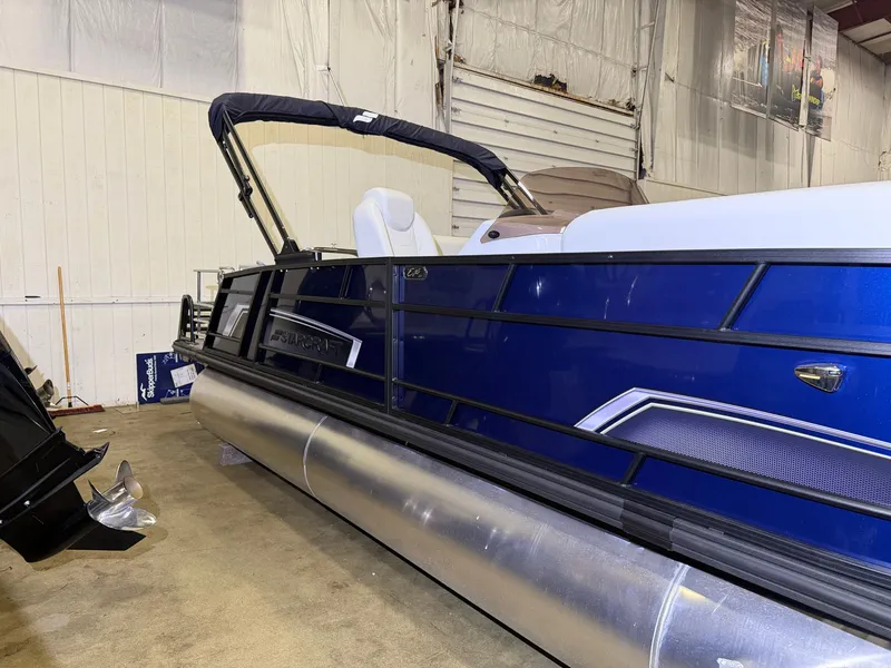 Slide: The Image of A blue Starcraft EX 20 Q DH pontoon boat from 2026 in a warehouse. - 6
