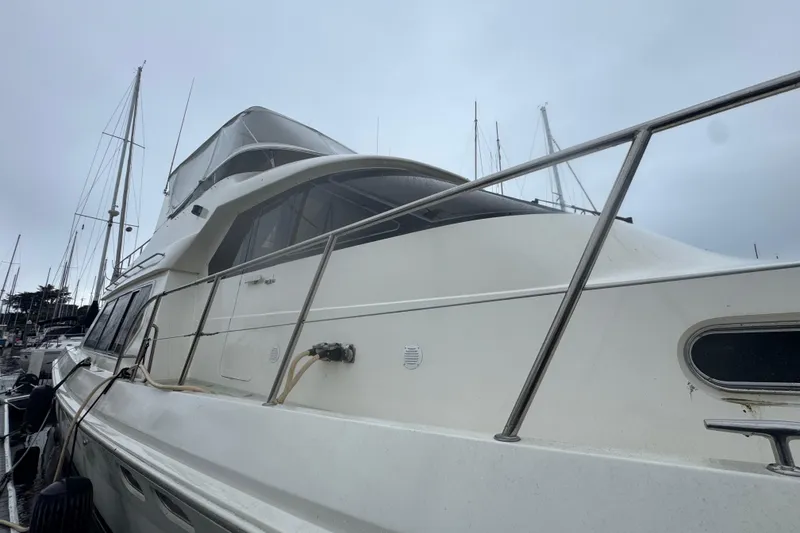 Slide: The Image of 2002 Hampton 550 yacht docked at marina under cloudy sky. - 11