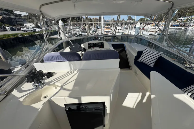 Slide: The Image of Helm of 2002 Hampton 550 yacht with seating and marina view. - 14