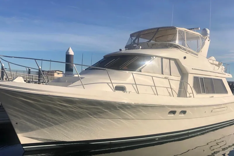 Slide: The Image of Luxury 2002 Hampton 550 yacht docked under clear blue sky. - 2