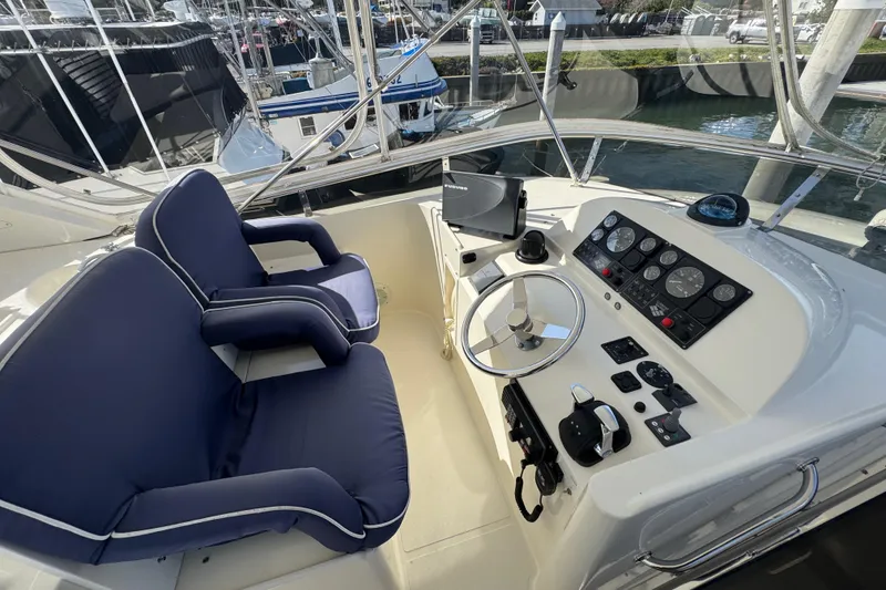 Slide: The Image of Cockpit of 2002 Hampton 550 yacht with blue seats and navigation controls. - 23