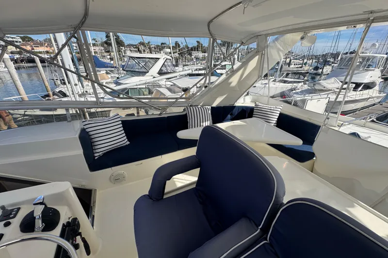 Slide: The Image of Luxurious 2002 Hampton 550 yacht interior with navy seating and marina view. - 24