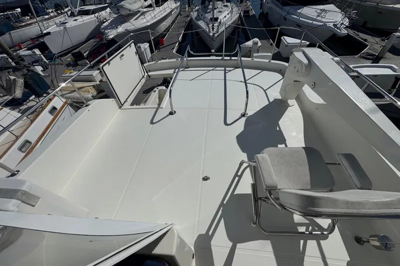 Slide: The Image of 2002 Hampton 550 yacht deck with seating, docked among other boats. - 25