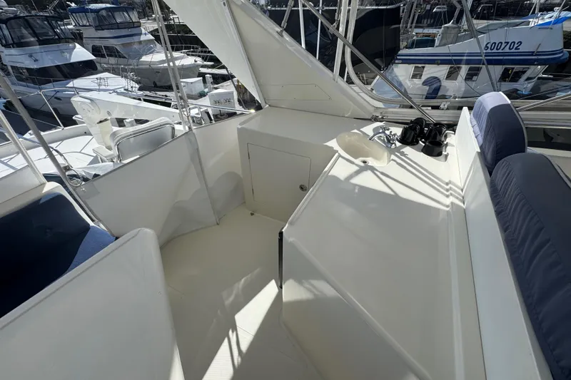 Slide: The Image of Flybridge of 2002 Hampton 550 yacht with seating and sink, docked at marina. - 26