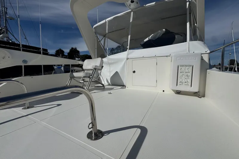 Slide: The Image of 2002 Hampton 550 yacht deck with seating and safety equipment under clear skies. - 28