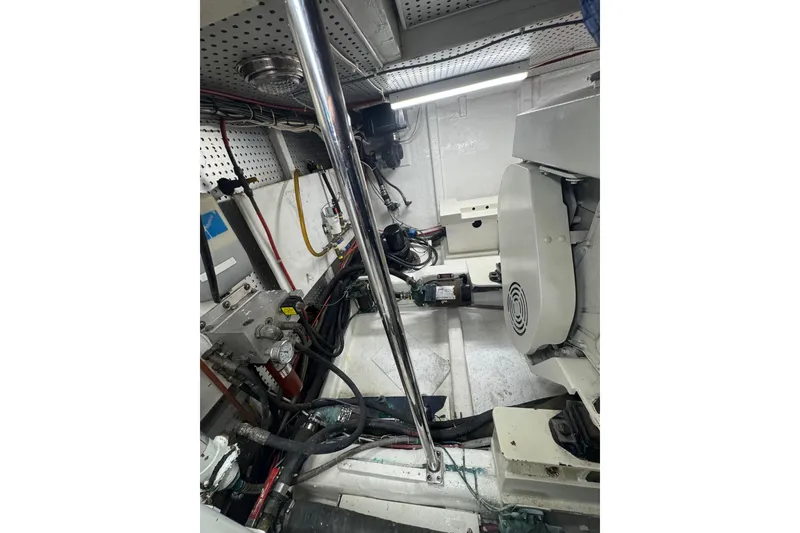 Slide: The Image of Engine room of a 2002 Hampton 550 yacht, featuring mechanical components and wiring. - 32
