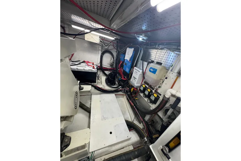 Slide: The Image of Engine room of a 2002 Hampton 550 yacht, featuring wiring and equipment. - 33