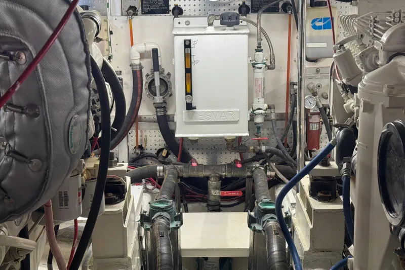 Slide: The Image of Engine room of a 2002 Hampton 550 yacht, featuring mechanical components and piping. - 40