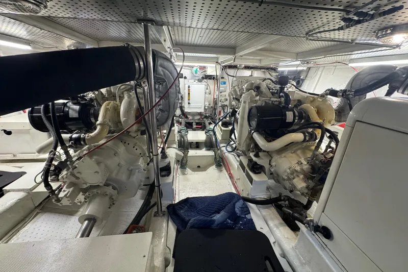 Slide: The Image of Engine room of a 2002 Hampton 550 yacht, showcasing dual engines and mechanical components. - 41
