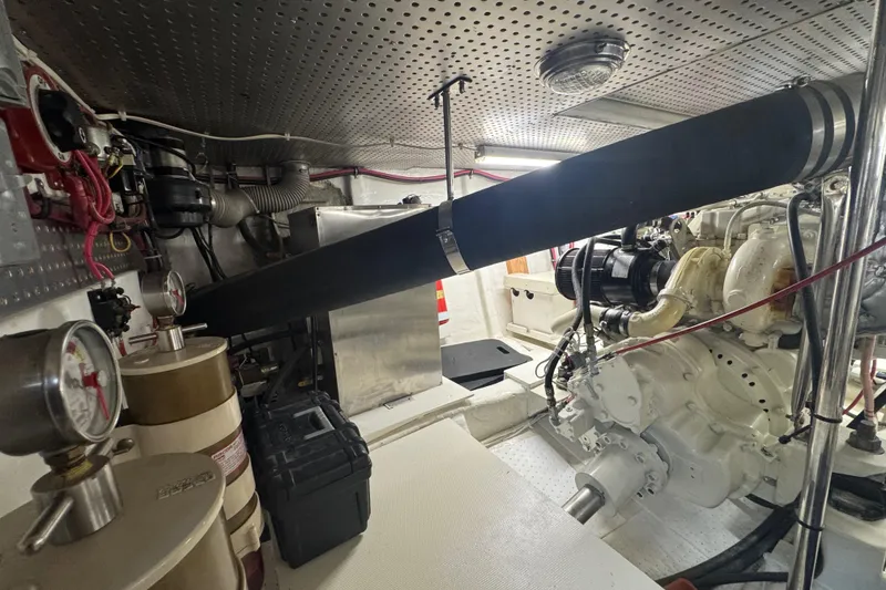 Slide: The Image of Engine room of a 2002 Hampton 550 yacht, featuring mechanical components and gauges. - 42