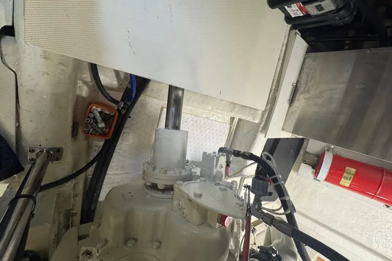 Slide: The Image of Engine room of a 2002 Hampton 550 yacht, featuring mechanical components and fire extinguisher. - 44