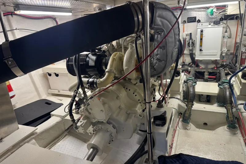 Slide: The Image of Engine room of a 2002 Hampton 550 yacht, showcasing mechanical components and wiring. - 45