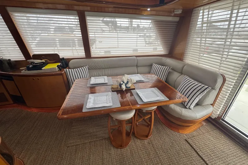 Slide: The Image of Luxurious dining area in a 2002 Hampton 550 yacht with elegant wood and leather seating. - 53