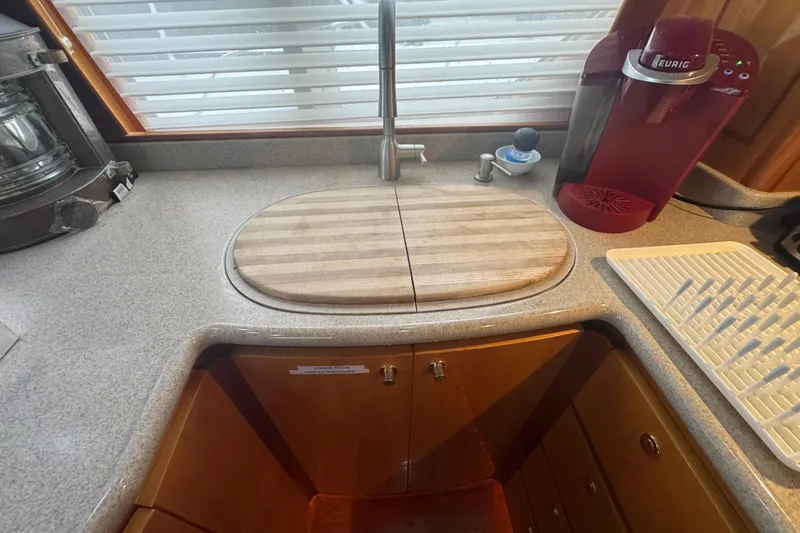 Slide: The Image of Kitchen area in a 2002 Hampton 550 yacht with sink, faucet, and coffee maker. - 56