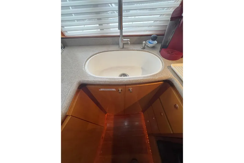 Slide: The Image of 2002 Hampton 550 yacht kitchen sink with wooden cabinetry and modern fixtures. - 57